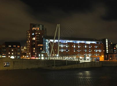 利兹克拉伦斯码头区运河入口的城市景观 一座人行天桥穿过水面 灯光反射 建筑物与夜空云彩相映成趣地标公寓旅游住宅建筑学天空天桥之路图片