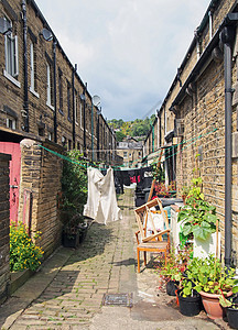 街道之间的后巷 西日日郡Hebden桥有几排传统石屋 在阳光明媚的夏日中线上洗干衣服和锅工厂图片