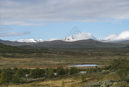 从挪威 E6 主干道出发 在自然公园欣赏山丘和雪山的秋景 云彩壮观远足开发高地项目蓝色森林戏剧性荒野岩石旅行图片