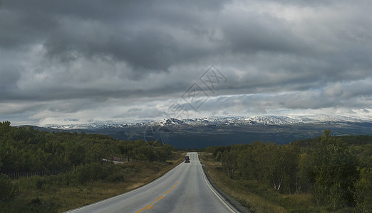 从挪威 E6 主干道出发 在自然公园蜿蜒的道路上欣赏山丘和白雪皑皑的山脉和壮观的云彩戏剧性旅行荒野项目缠绕蓝色开发曲线云景远足图片