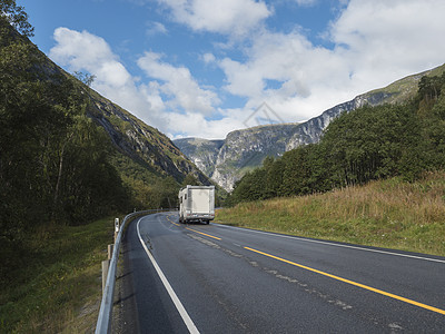 在Winding路E136号的白色野营车中 有山地大块头在挪威罗姆斯达尔山谷的Troll墙Trollveggen 蓝天白云夏季公图片
