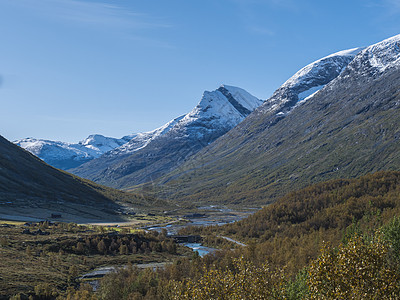 Leirdalen 山谷拥有白雪皑皑的山峰 森林和狂野的河流 挪威尤通黑门山国家公园的自然景观 初秋蓝天背景缠绕公园远足劳马风景图片