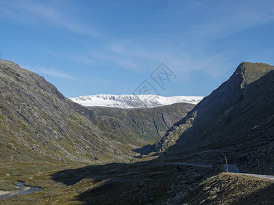 莱尔达伦谷 有白雪皑皑的山峰 森林 狂野的河流和 55 号公路风景路线 挪威 蓝天背景图片