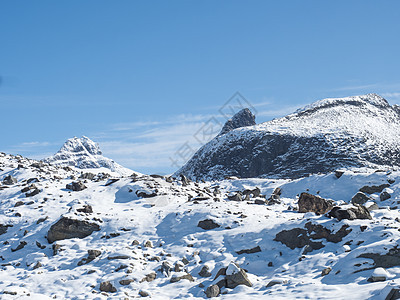 挪威和斯堪的纳维亚 约顿海宁国家公园最高的雪覆盖山峰 日落之日 蓝天空背景冒险小刀高山岩石旅行顶峰太阳店铺山脉冰川图片
