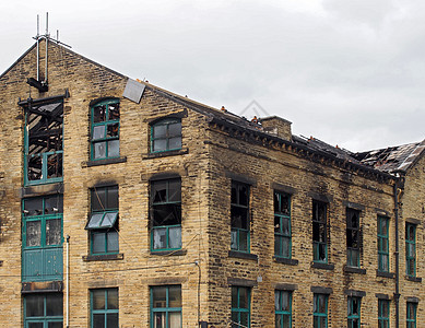 一场大火后 一栋被烧毁的大型旧工业建筑的破屋顶和破窗户建筑学损害玻璃煤烟犯罪状况经济城市垃圾苦恼图片