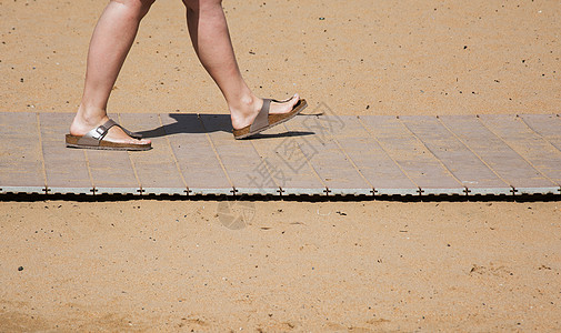 夏季脚踏在沙滩沙田上的石板上图片