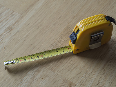黄黄色测量胶带测量 显示木制背景的10厘米图片