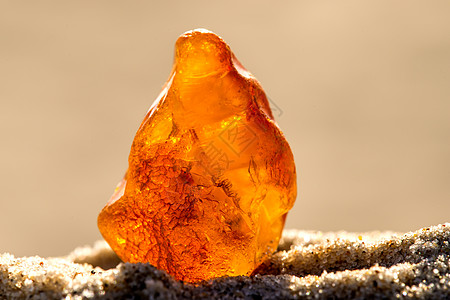 在波罗的海的海滩上安珀石头材料康复首饰树脂橙子宏观果汁矿物岩石背景图片