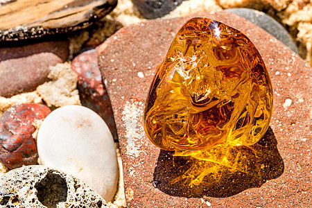 在波罗的海的海滩上安珀宏观水晶岩石矿物材料宝石树脂化石石头果汁背景图片
