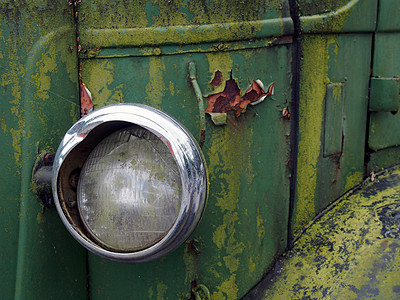 一辆老旧的废弃卡车车头灯紧闭处 车上有生锈的绿色烤箱和面板运输风化古董腐蚀褪色乡愁金属破坏垃圾废料图片