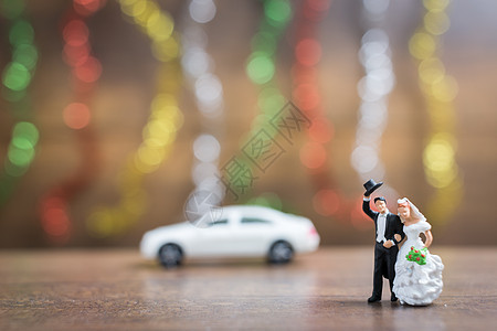新郎和新娘 在木制地板上与多彩的木地板上庆典男性玩具裙子婚姻情人幸福妻子花束已婚图片