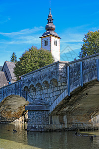 圣约翰浸信会教堂和斯洛文尼亚博欣吉湖边的一座桥梁游客浸信会旅行教会公园教堂森林季节草地天空图片
