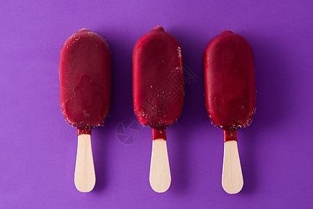 紫罗兰背景的草莓冰棒白色巧克力红色食物小吃奶油甜点冰淇淋水果粉色背景图片