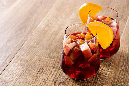 红葡萄酒甜点 在木制桌上的玻璃杯中液体柠檬橙子投手水果玻璃酒精红色热带饮料图片