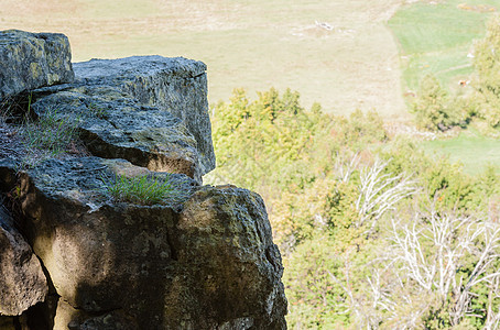 在悬崖边缘的岩石 与远处的田地相对图片
