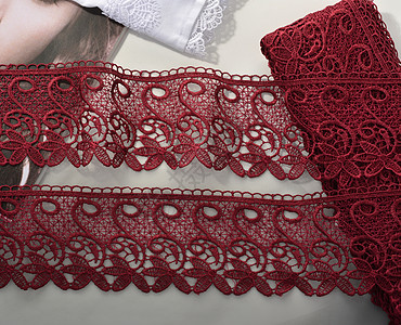 红色的胶带 温柔的瓜质 光背景上的美容蕾丝织物棉布工艺纺织品海浪针线活奢华缝纫丝带丝绸店铺背景图片