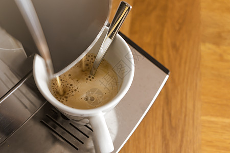新鲜咖啡从咖啡机跑到白色的一头宏观咖啡师美食香气制作者食物厨房饮料餐厅酒吧图片