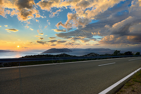 日落时美丽的沿海公路海洋天空小路运输路线安全山脉车道交通海滩图片