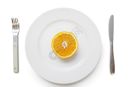 盘子上的橙色十字口带叉和刀 在白背景上架着叉子和刀横截面对象金属橙子影棚营养食物水果餐具生产图片