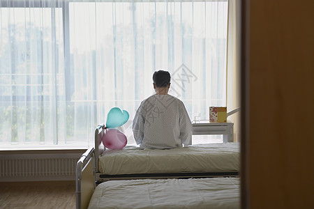 病人坐在医院的床边 被气球挡在后视线药品病床疾病男子医学一人卫生棕色中年寂寞图片