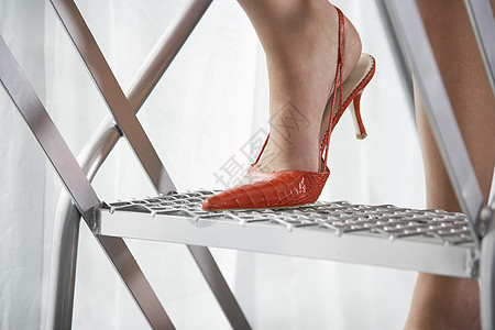 身穿红色高脚鞋 站在铝上站立的红高铁皮鞋的妇女一人身体女士高跟鞋工作室影棚梯子设计一部分办公室图片