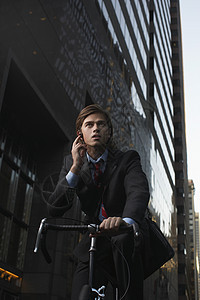 在街上站着骑自行车的人在手机低角度视图下说话图片