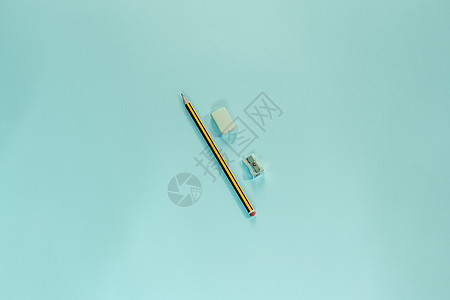 一支铅笔 一根抹布机和一把笔刀 在蓝色面纸壁纸上背景图片
