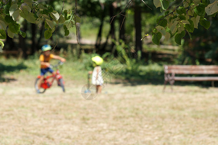 照片模糊 小孩骑自行车在公园里用脚踏车图片