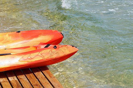 海上附近一个木头码头上两条皮艇假期橙子旅行冒险支撑蓝色天空海洋塑料海岸图片