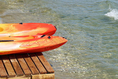海上附近一个木头码头上两条皮艇支撑旅行天空假期游客晴天橙子海洋塑料蓝色图片