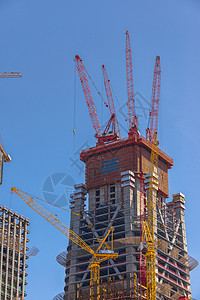 在蓝色天空下建造摩天大楼机器高楼脚手架建筑商业工程建筑学框架城市工地图片