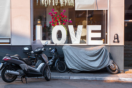 商店窗户上贴近爱之词的摩托车 爱情的标志和象征图片