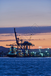港口的起重车和船舶货运平台码头血管起重机船运货物日落贸易天空图片