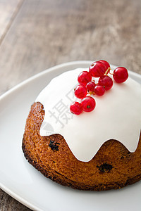 木制桌上的圣诞布丁季节性木头食物甜点庆典红色坚果水果蛋糕图片