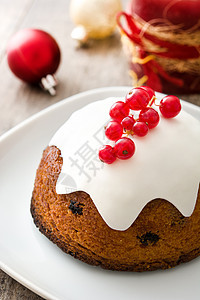 木制桌上的圣诞布丁蛋糕庆典甜点季节性坚果红色水果食物木头图片