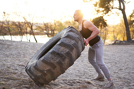 强力男子训练锻炼运动 在户外DY健身房举起大轮胎活动重量成人身体活力奉献男性二头肌专注精神图片