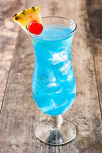 木桌上的蓝夏威夷鸡尾酒苏打液体饮料桌子菠萝热带水果酒精背景图片