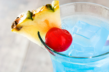 木桌上的蓝夏威夷鸡尾酒桌子酒精热带液体水果菠萝饮料苏打图片