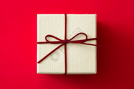 红色背景的白色礼品盒丝带盒子庆典生日礼物背景图片