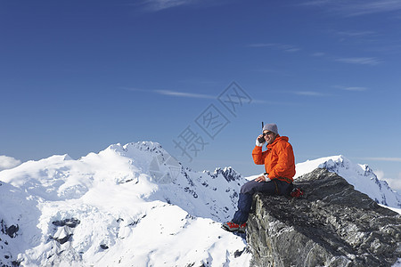 山峰上使用对讲机的登山者男子成人服装男人中年顶峰一人运动中年人攀岩图片