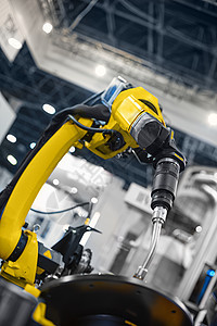 工作在工业环境的自动机器人胳膊汽车黄色工厂工程师机械工具工程制造业金属生产图片