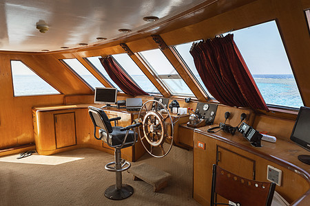阳光下乘船驾驶舱座舱房间椅子木头车轮驾驶运输旅行方向盘假期图片