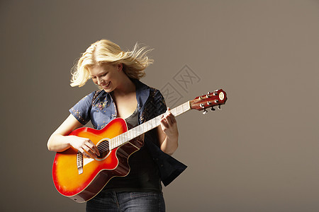 玩吉他的女人笑着带着风吹头发图片