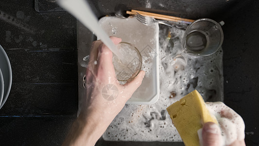 在黑水槽中洗脏餐具清洁剂玻璃卫生海绵肥皂厨房房子食物工作清洁工图片