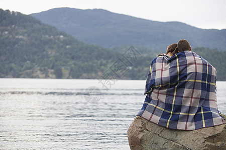 一对夫妇用毯子包着 坐在岩石上的海边中年人摄影休闲女性男子大海风景成人地平线夫妻图片