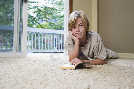 男孩1012躺在地毯阅读书上服装爆头活动专注头发肩膀头肩一人房子休闲图片