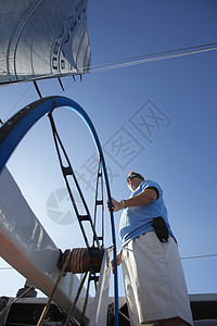 驾驶船轮上的男水手游艇娱乐队长假期旅游旅行帆船飞行员控制男性图片