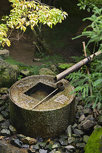 日本 京都良治寺石质流域钢包竹子饮水机纯化洗手盆文化仪式鹅卵石背景图片