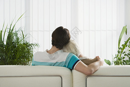 坐在沙发上拥抱着背面的一对情侣长椅男性娱乐男朋友女士妻子女性电视电影家庭图片