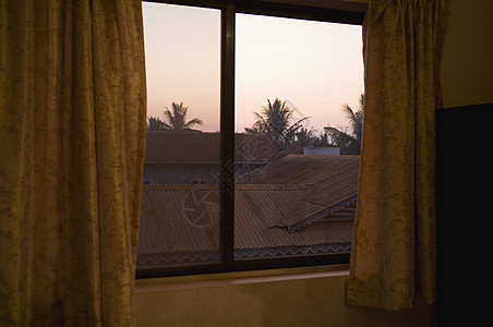 通过窗口所见的瓷砖屋顶窗帘瓦片日落屋面窗户建筑布料房顶建筑学图片